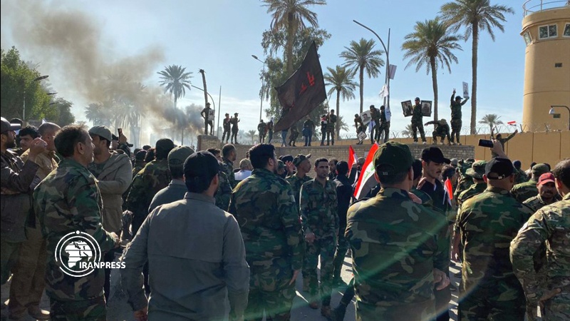 Iranpress: عراقيون غاضبون يضرمون النار بإحدى بوابات سفارة امريكا في بغداد