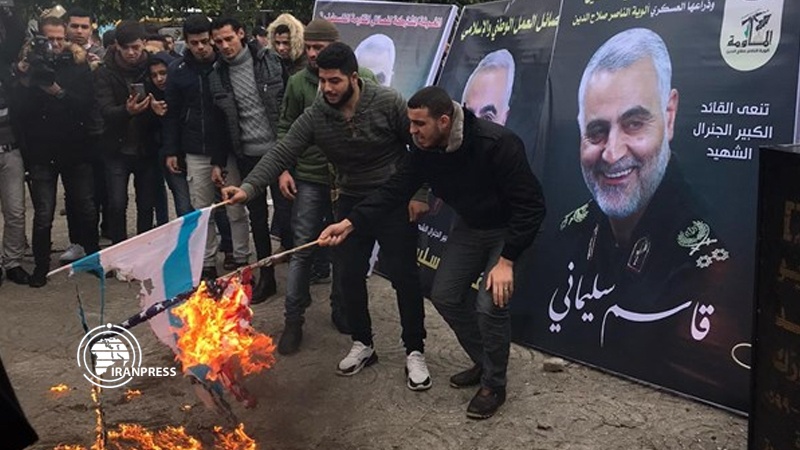 Iranpress: Palestinian torch American, Israeli flags during Lt. Gen Soleimani commemoration ceremony
