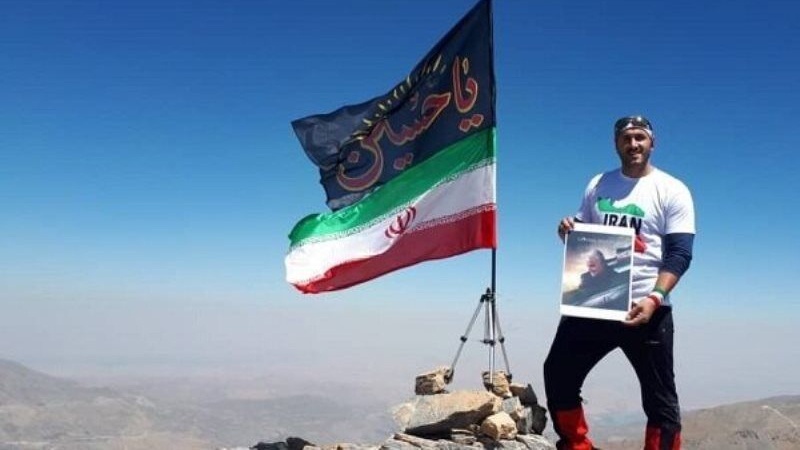 Iranpress: متسلّق جبال إيراني يرفع علم "يا حسين" على قمة "شيخا دار" في العراق
