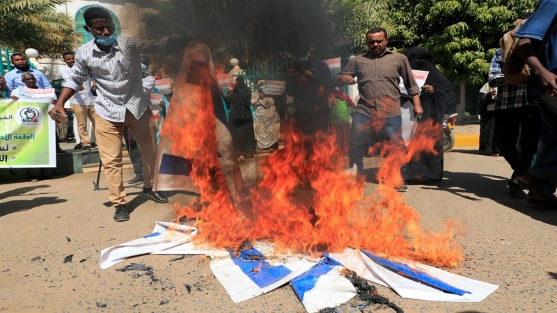 Iranpress: محتجون سودانيون يحرقون علم إسرائيل احتجاجًًا على اتفاق التطبيع