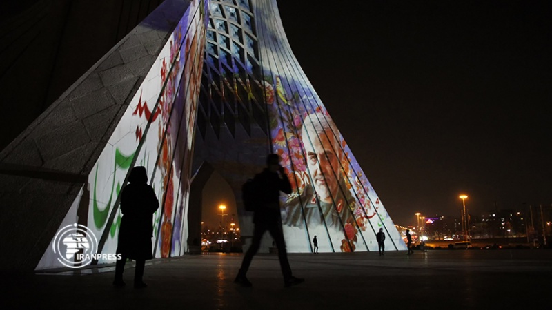 Iranpress: إضاءة برج آزادي في طهران بصور قادة النصر
